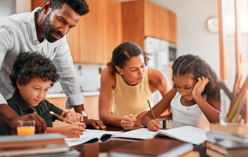 Help your child manage his or her time. Shot of parents helping their two children with their homework.